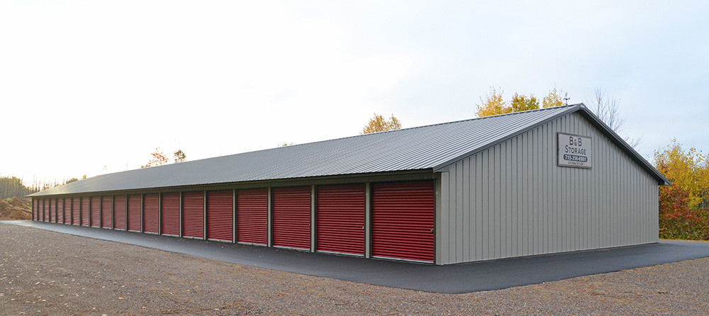 gray post frame storage facility with red doors